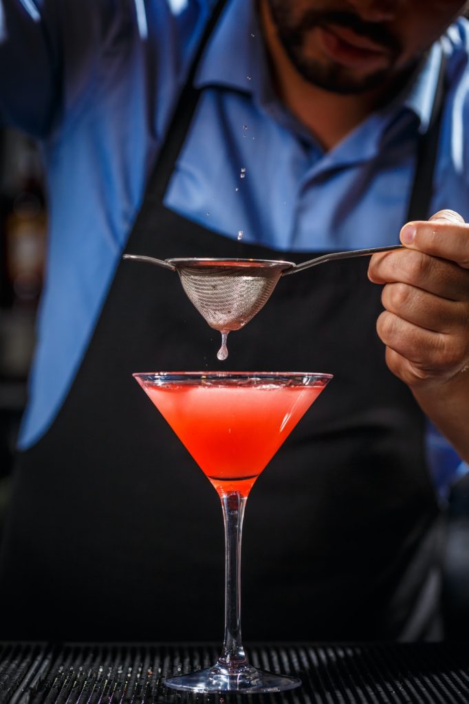 Barman makes cosmopolitan cocktail